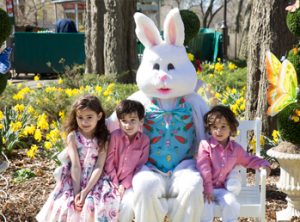 Three children taking a photo with the Easter Bunny atEaster Egg-stravaganza