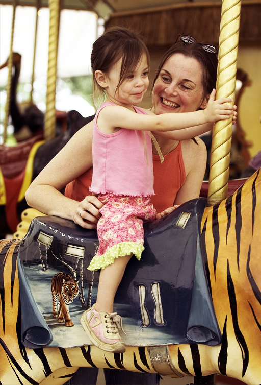 Adult and child riding the AT&T Endangered Species Carousel