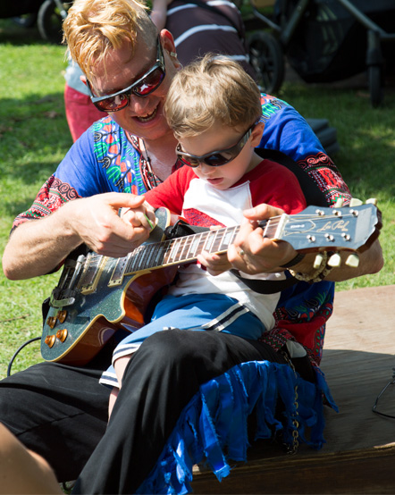 Mr. Singer teacher a child to play the guitar