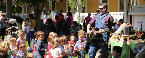 Mr. Singer plays the guitar for enthusiastic children