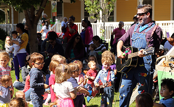 Mr. Singer playing the guitar for children