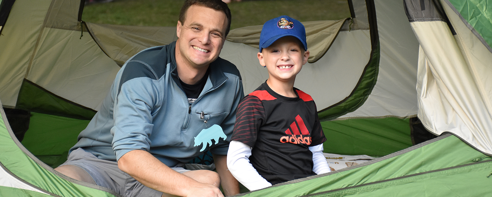 Father and son getting ready to camp in their tent