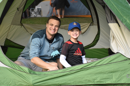 Father and son getting ready to camp in their tent