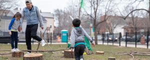 Children play on tree stumps at their local community park