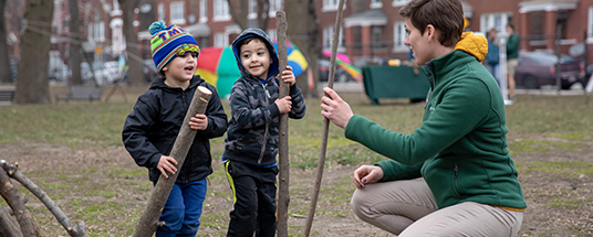 A zoo educator shows children how to play with sticks