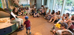 A zoo educator reads a book to children and their families