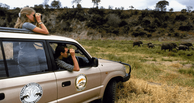 Charles and Lara Foley watching wild animals in Tanzania