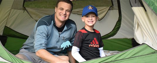 A child and his dad in a tent