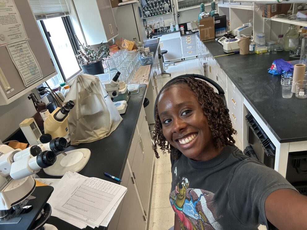 A selfie of a Black woman in a laboratory setting